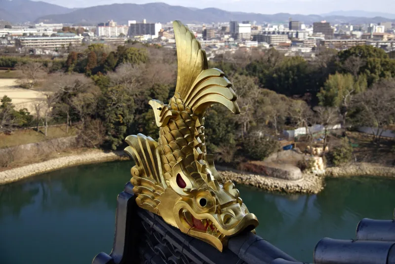 Golden shachihoko roof ornament on Okayama Castle overlooking the moat and the city
