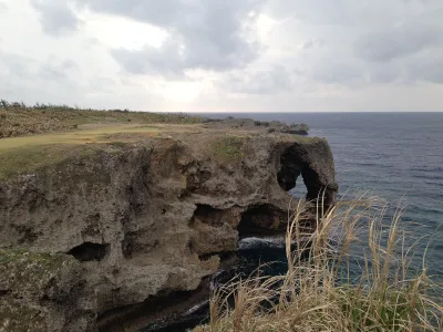 The elephant-trunk shaped limestone rock arch at Cape Manzamo above the East China Sea