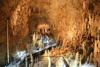 A lit walkway through the Gyokusendo cave lined with countless stalactites