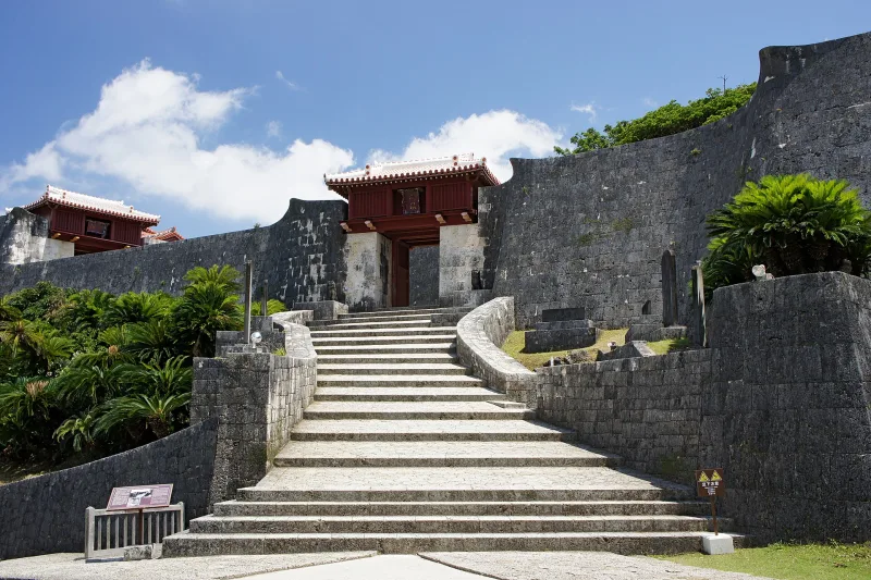 Curved stone walls and stairs leading to a gate inside Shuri Castle