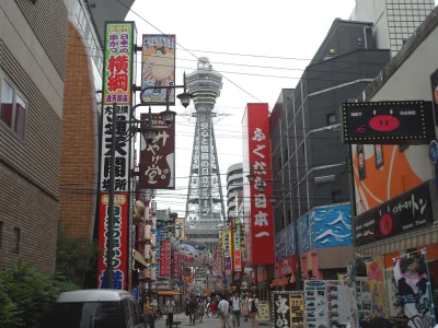 Tsutenkaku Tower rising above the colourful shop signs of Shinsekai, Osaka