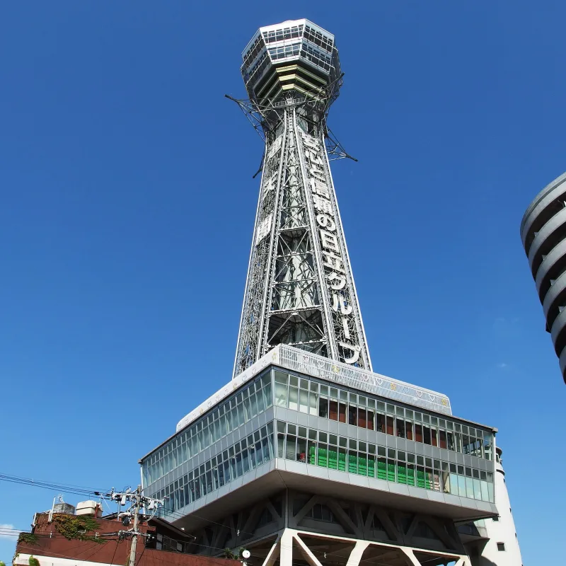 Tsutenkaku Tower's observation decks seen from below against a blue sky