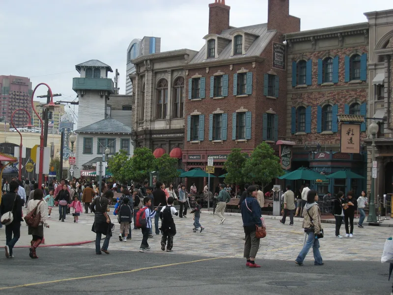 Visitors walking past brick buildings styled like an old American city street at Universal Studios Japan