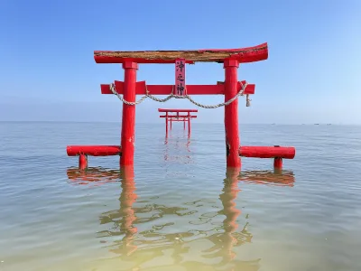 Red torii gates standing in the calm sea at high tide at Ouo Shrine, Tara