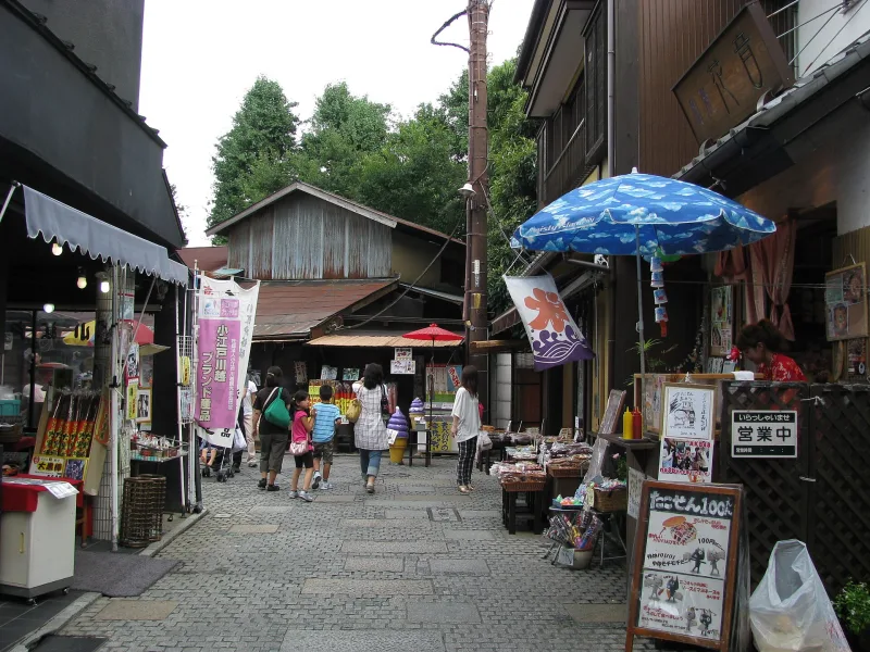 Visitors walking past small traditional sweet shops in Kashiya Yokocho, Kawagoe
