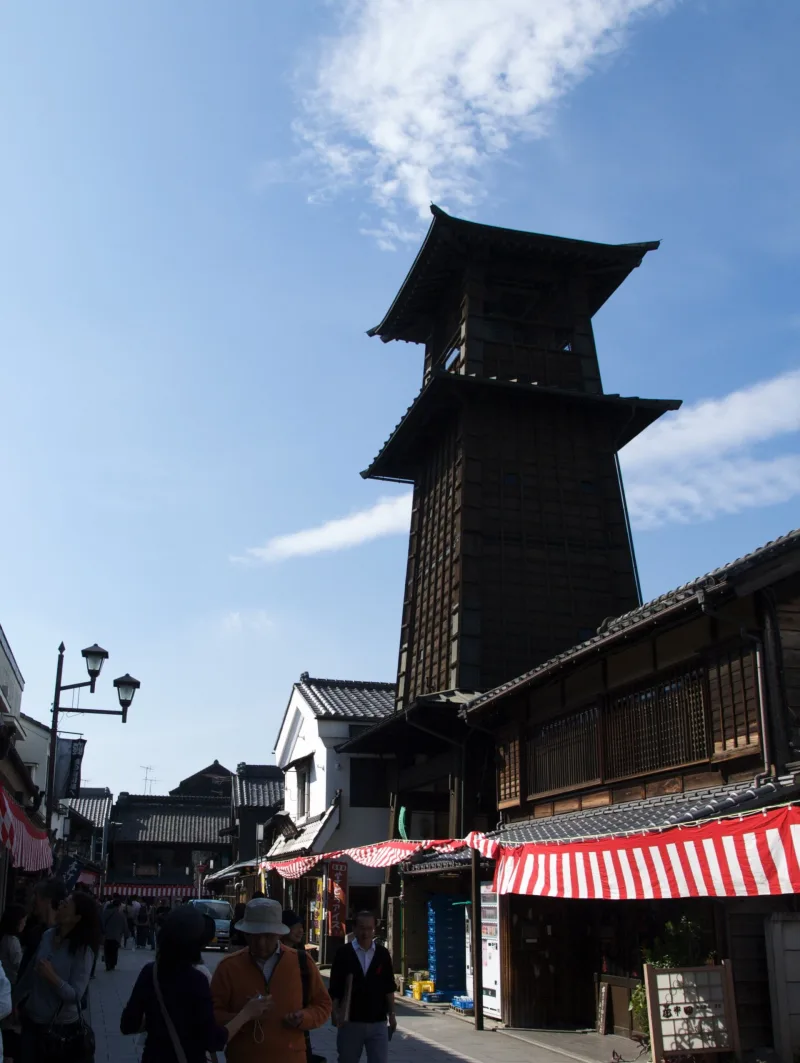 Toki no Kane bell tower seen from the street in Kawagoe's old town under a blue sky