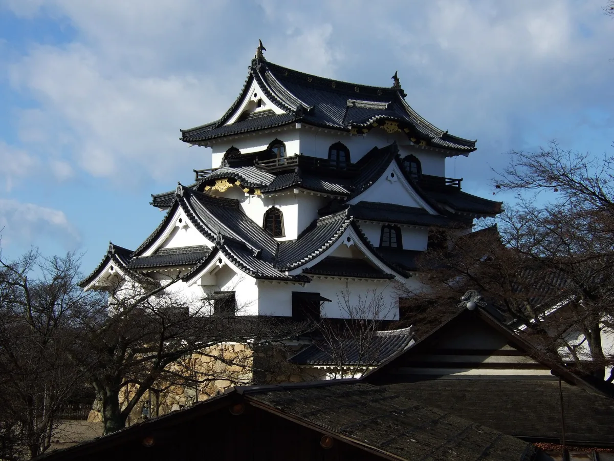 The white three-story keep of Hikone Castle under a blue sky