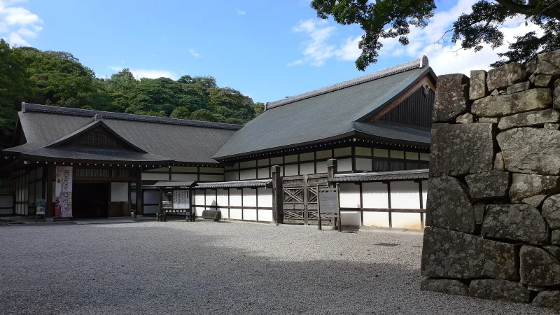 Hikone Castle Museum, a traditional white-walled building beside the castle's stone wall