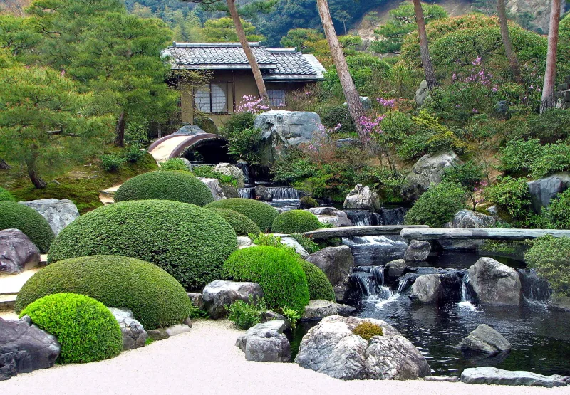 Pond and small cascades among clipped shrubs in the Adachi Museum of Art garden