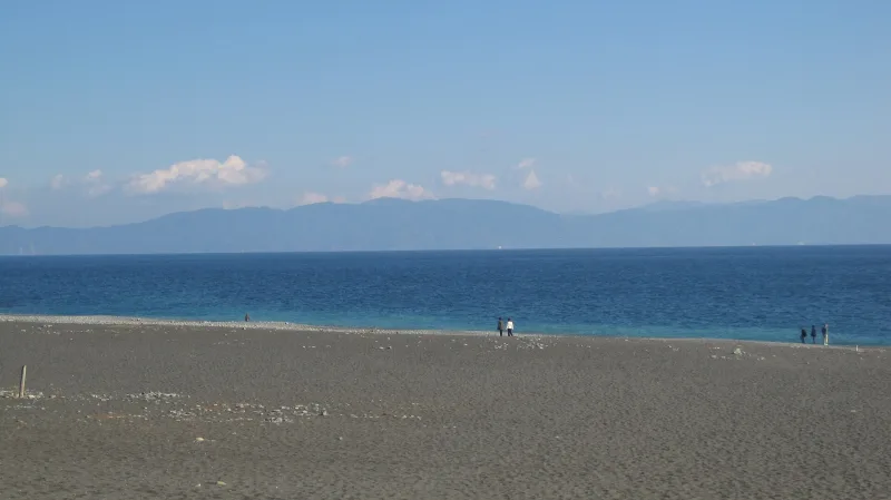 Dark sand beach at Miho facing the blue water of Suruga Bay with distant mountains