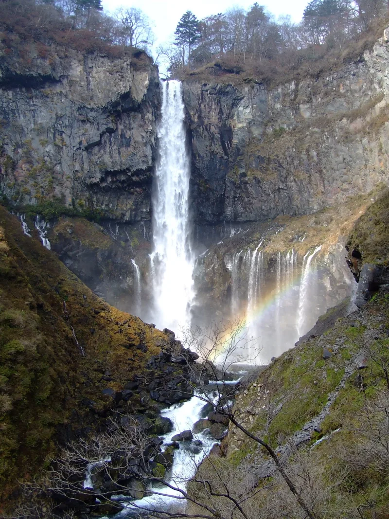 Kegon Falls with a rainbow in the spray and smaller falls along the cliff