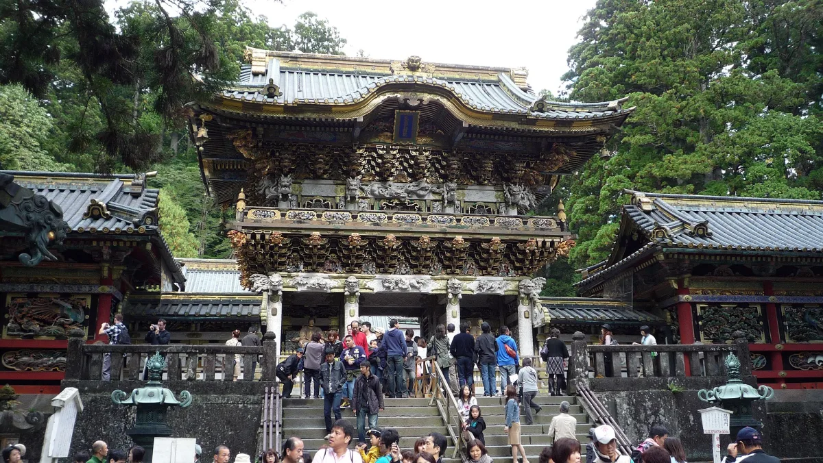 The ornate white and gold Yomeimon Gate of Nikko Toshogu at the top of stone steps