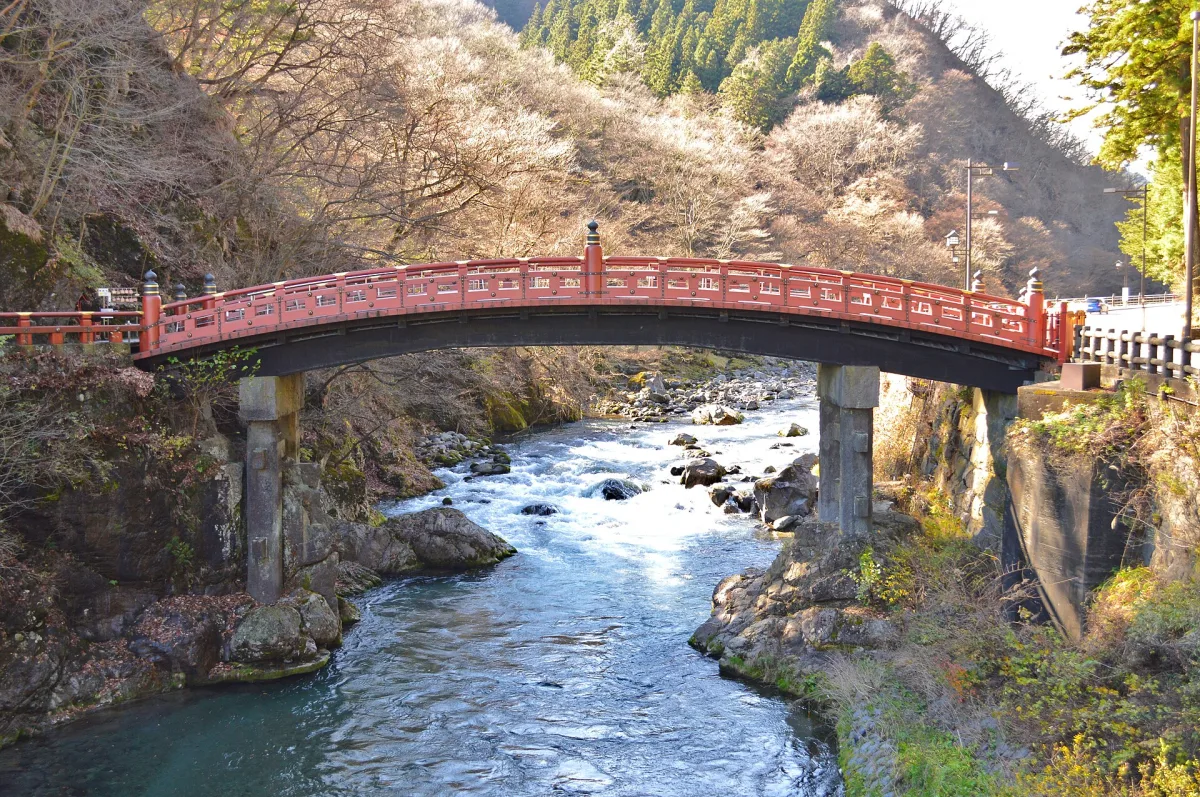 Vermilion Shinkyo Bridge arching over the clear Daiya River in Nikko
