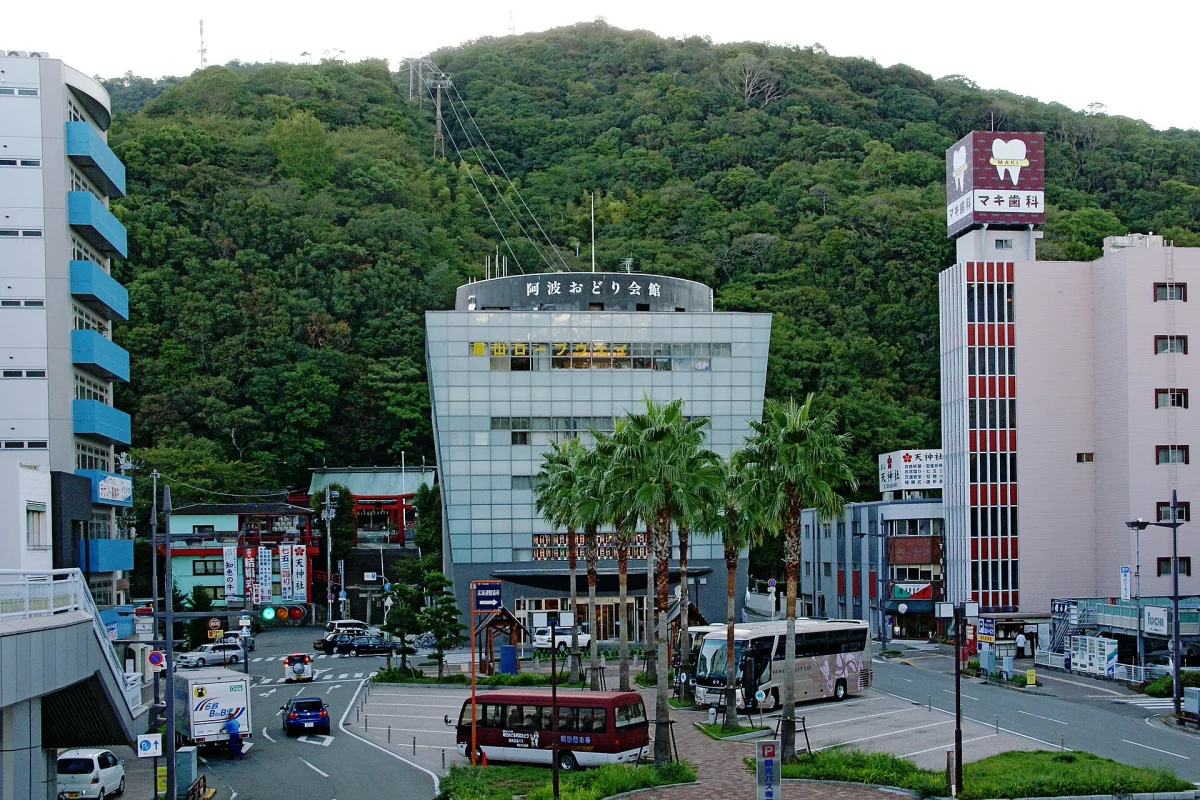 The glass-fronted Awa Odori Kaikan at the foot of forested Mount Bizan in central Tokushima
