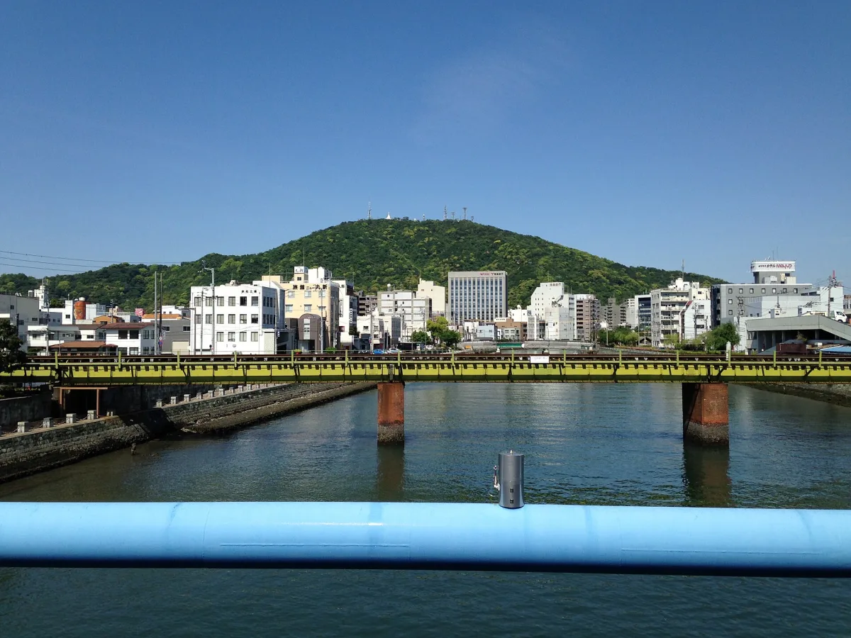The green, gently sloping Mount Bizan rising behind the Shinmachi River in Tokushima city