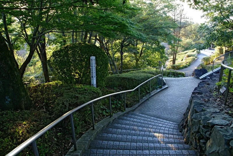 A stone-paved path winding up through trees in Bizan Park