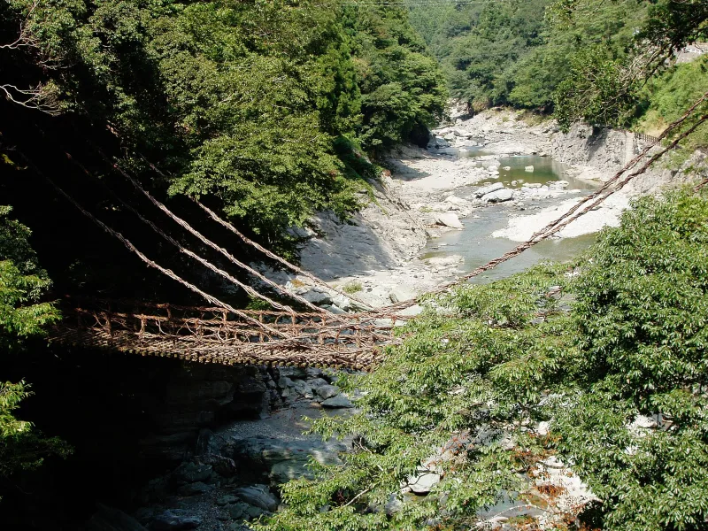 Iya Kazurabashi, a bridge woven from vines, hanging over a clear mountain river