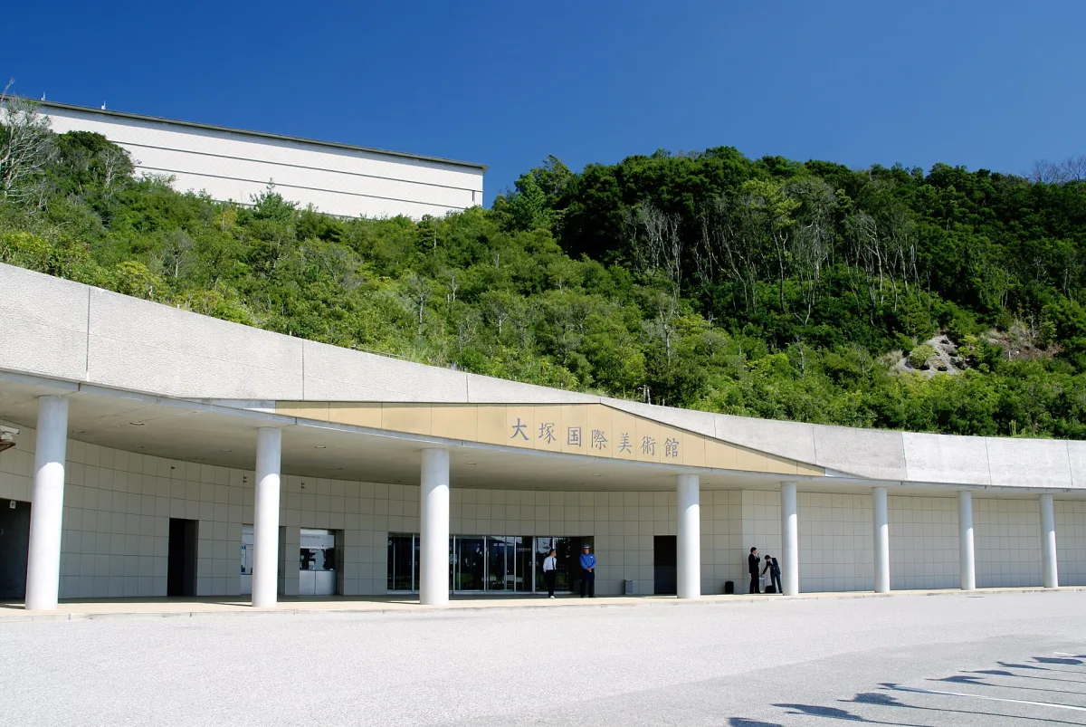 The entrance building of the Otsuka Museum of Art, set into a green hillside in Naruto