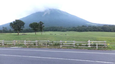 Mount Daisen rising behind the green pasture of Daisen Makiba Milk no Sato