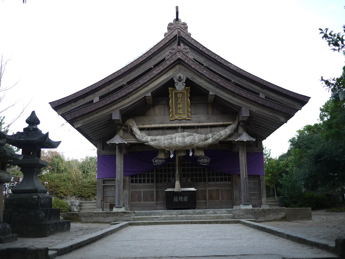Front of the wooden main hall of Hakuto Shrine with a stone lantern
