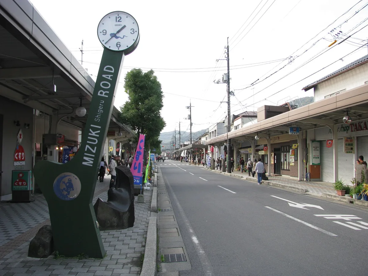 Mizuki Shigeru Road in Sakaiminato with its green clock-topped road sign and shopping street