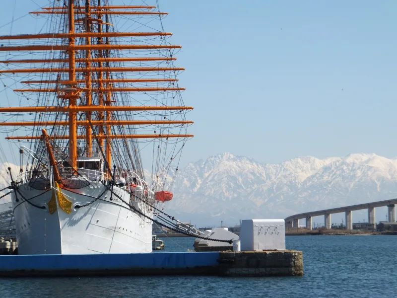 Masts of Kaiwo Maru with the snowy Tateyama mountains behind