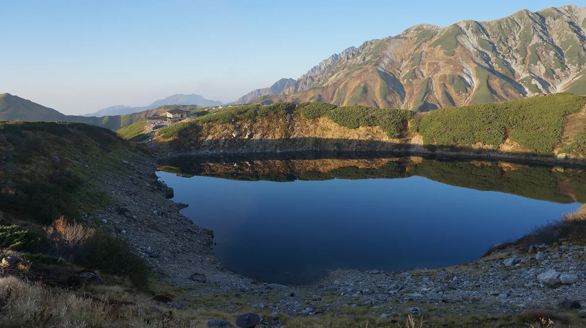 Mikurigaike Pond in Toyama, surrounded by mountain slopes