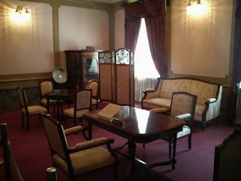 Restored guest room at Bunshokan with period sofas, red carpet and wood panelling