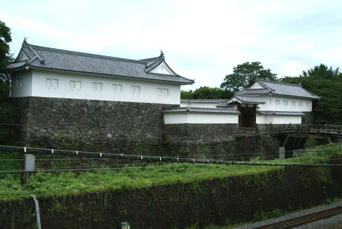 The rebuilt white Higashi-Otemon gate of Yamagata Castle above its stone walls and moat