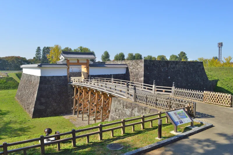 Restored stone walls and wooden bridge at the inner citadel of Yamagata Castle in Kajo Park