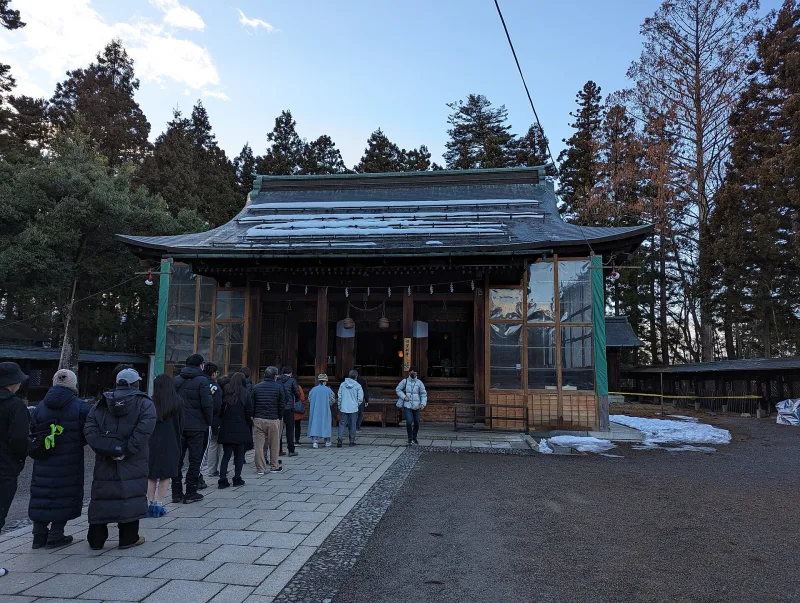 Worshippers in front of a shrine hall on the Yonezawa Castle grounds in winter
