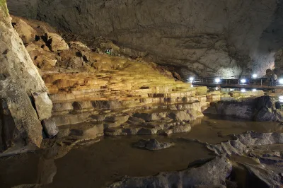 Lit terraces of rimstone pools inside the huge chamber of Akiyoshido Cave