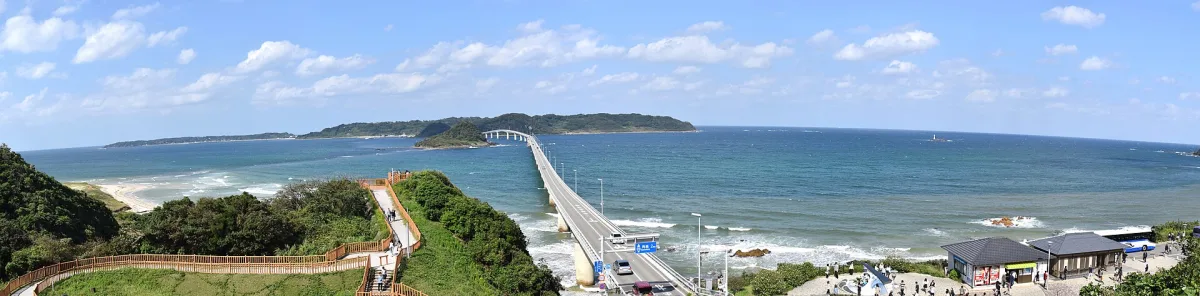 A panoramic view of Tsunoshima Bridge crossing the blue sea.