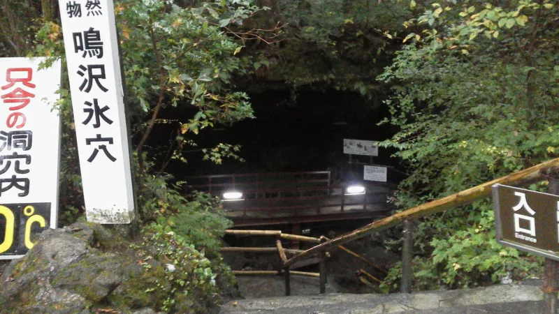 Stone steps and railings leading down to the entrance of Narusawa Ice Cave in the forest